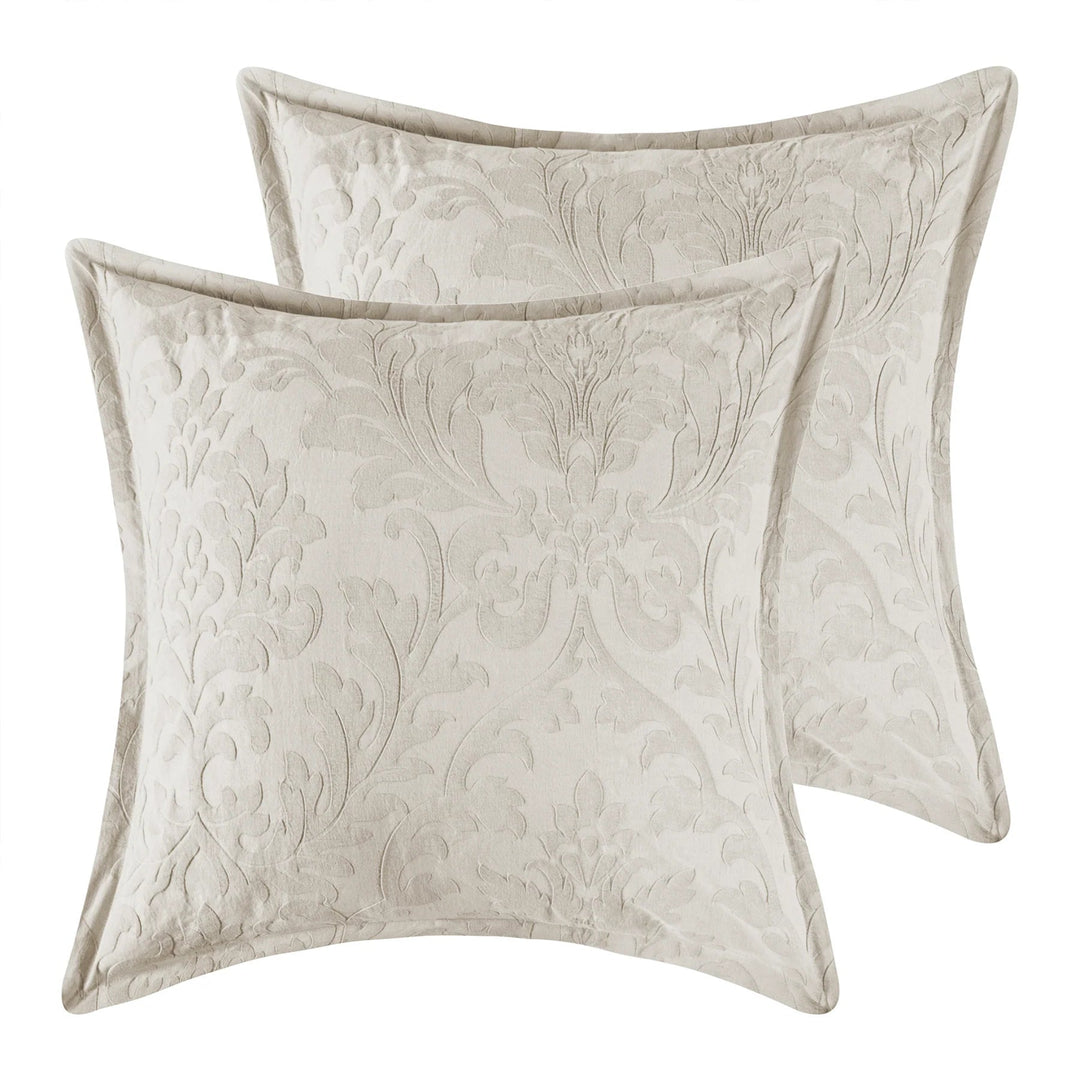 Two beige decorative pillows with floral patterns on a white background