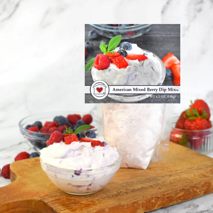 American Mixed Berry Dip Mix with whipped cream and berries on a wooden board.