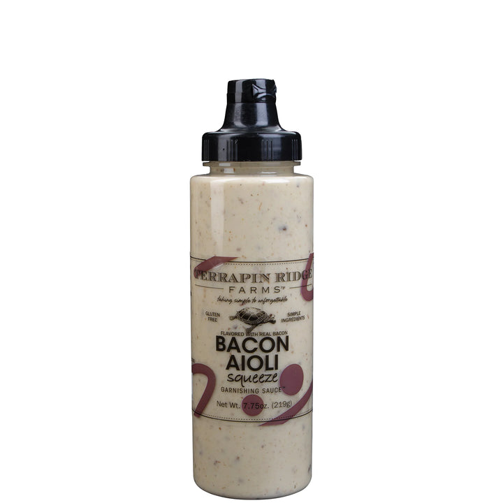 A bottle of Ferrapin Ridge Farms Bacon Aioli Squeeze dressing with a black cap, filled with a creamy beige aioli sauce speckled with herbs, on a white background.