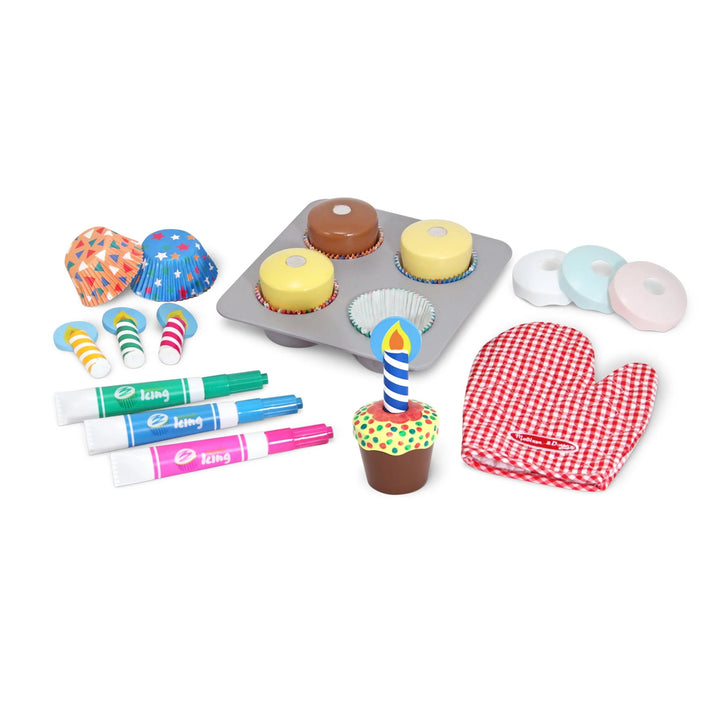Toy baking set with cupcakes, oven mitt, and markers on a white background