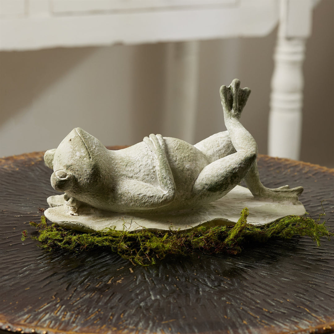 Decorative frog sculpture on a wooden surface with a blurred background
