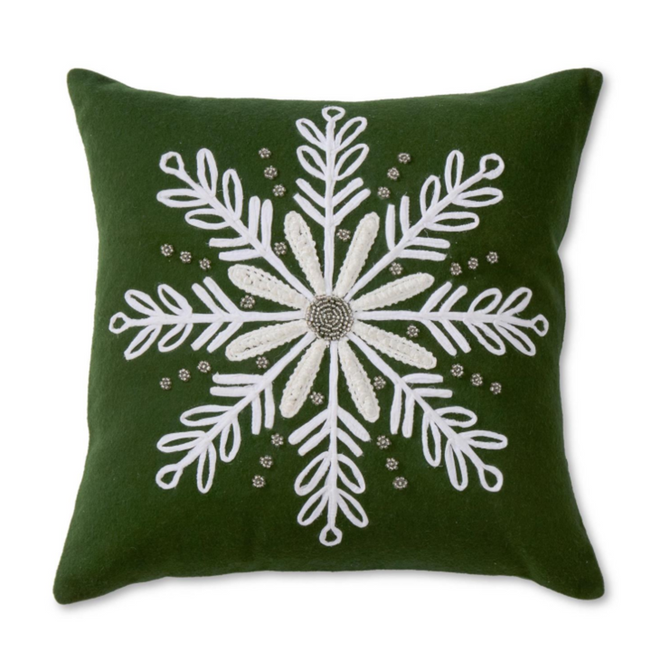 A square dark green throw pillow featuring a large white embroidered snowflake design with a beaded center, shown against a plain white background.