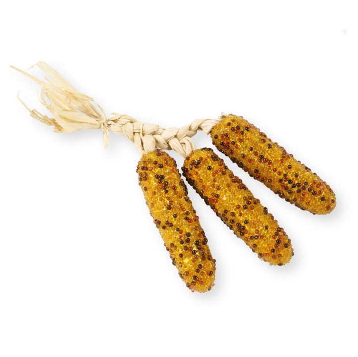 Three corn on the cob with a textured surface on a white background