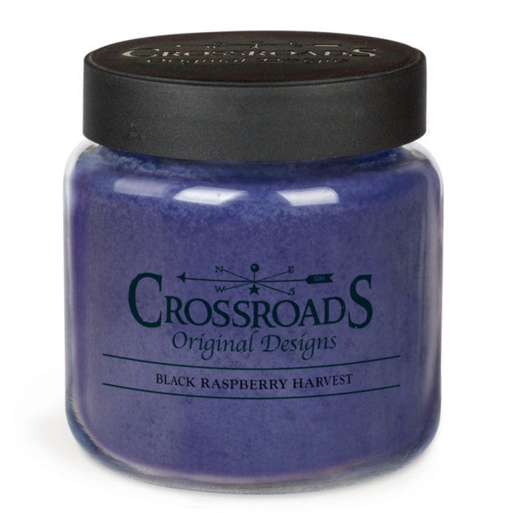 Purple candle jar with black lid labeled 'Crossroads Original Designs' on a white background