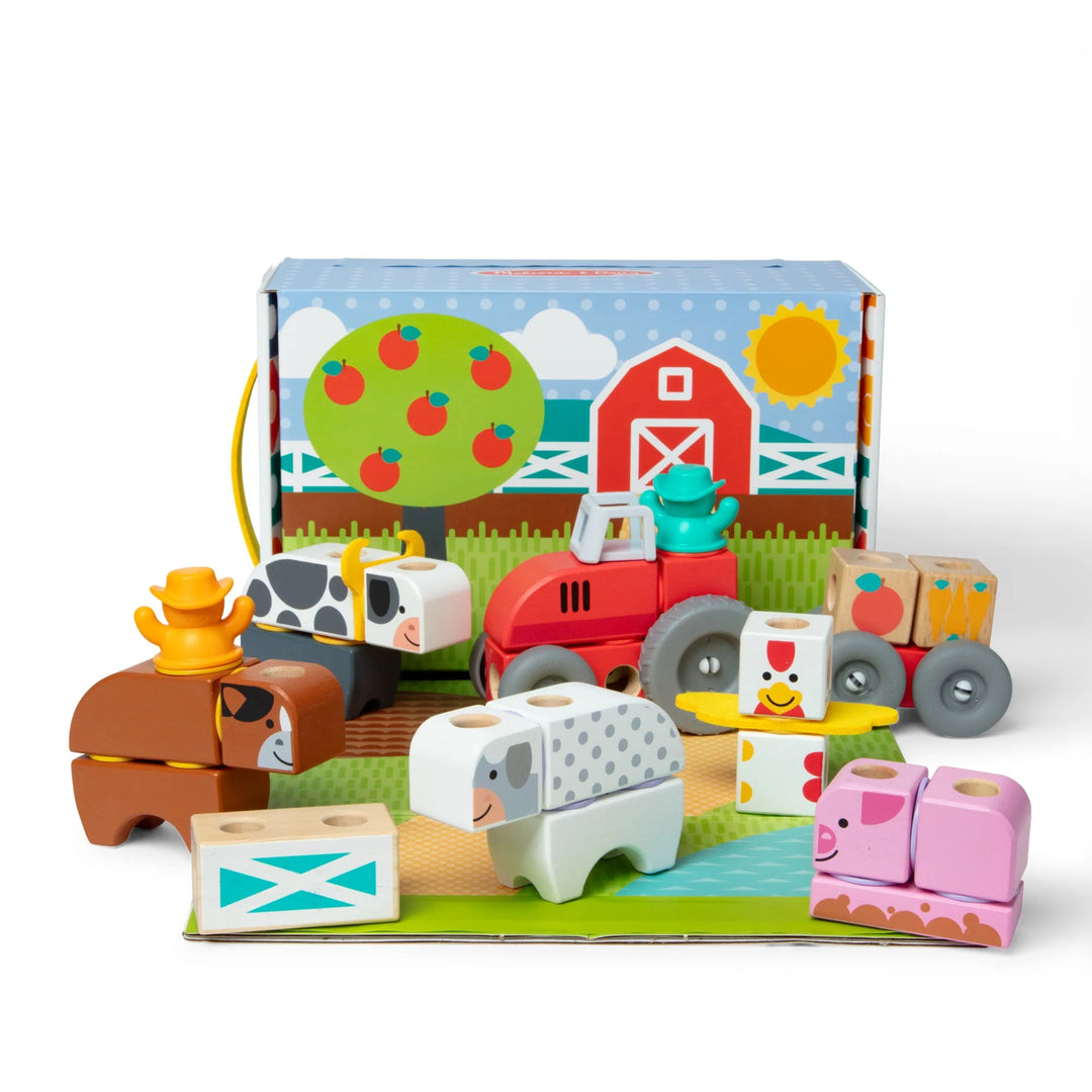 Wooden farm toy set with animals and a barn on a white background