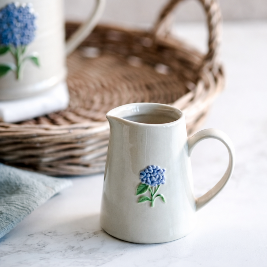 White ceramic mug with blue floral design on a marble surface
