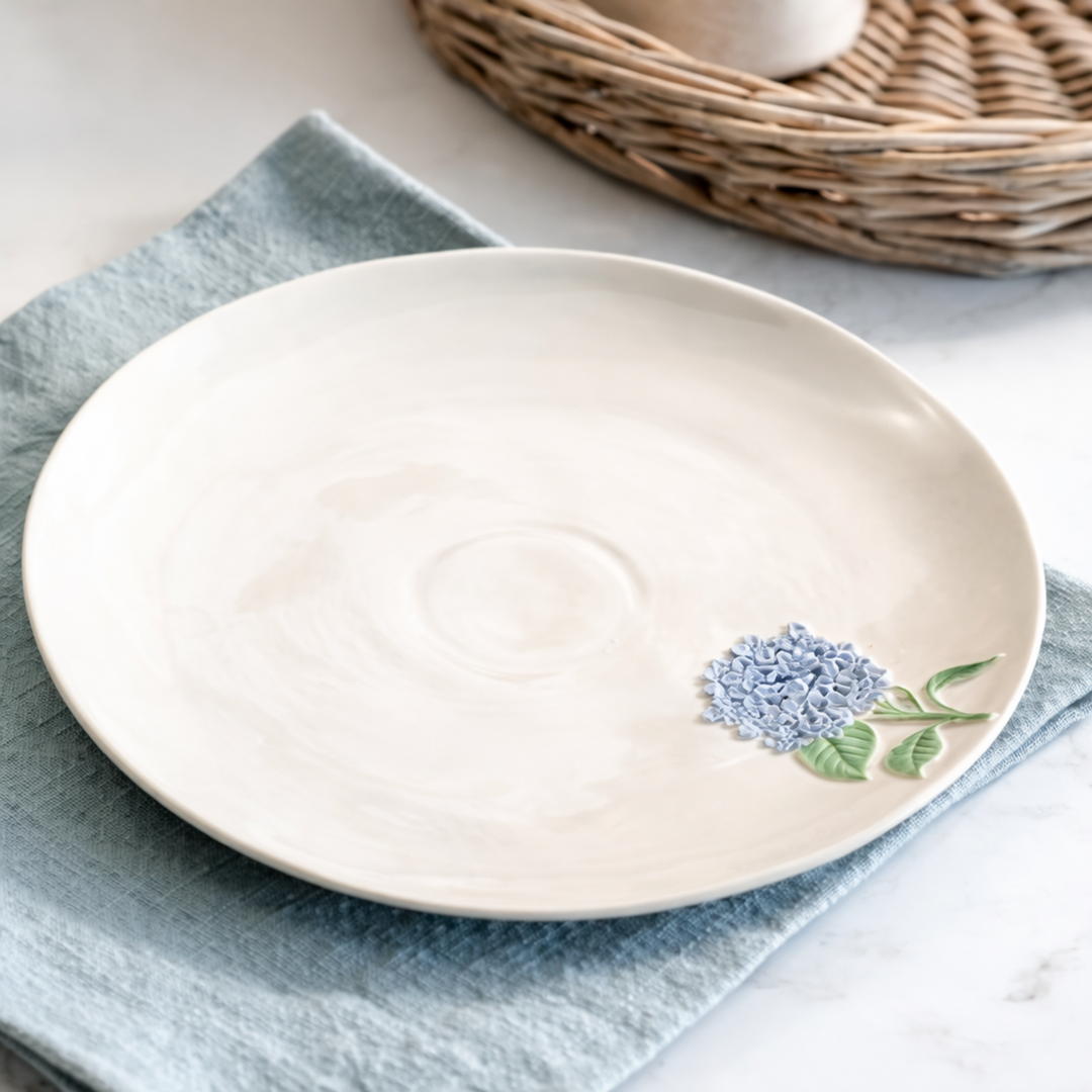 Blue Hydrangea Ceramic Plate on blue napkin with wicker basket in the background