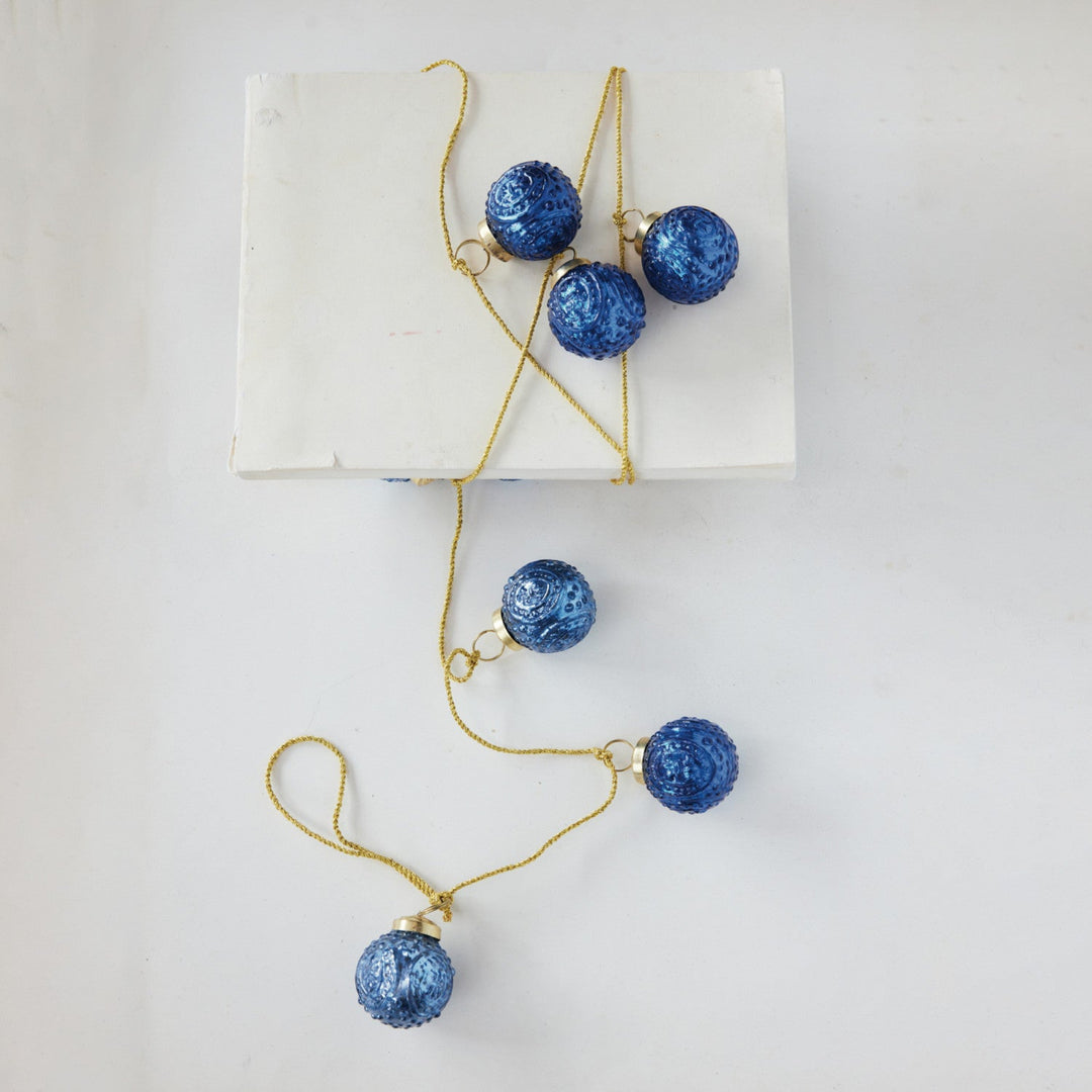 Jewelry set with blue spherical pendants and gold chains on a white background