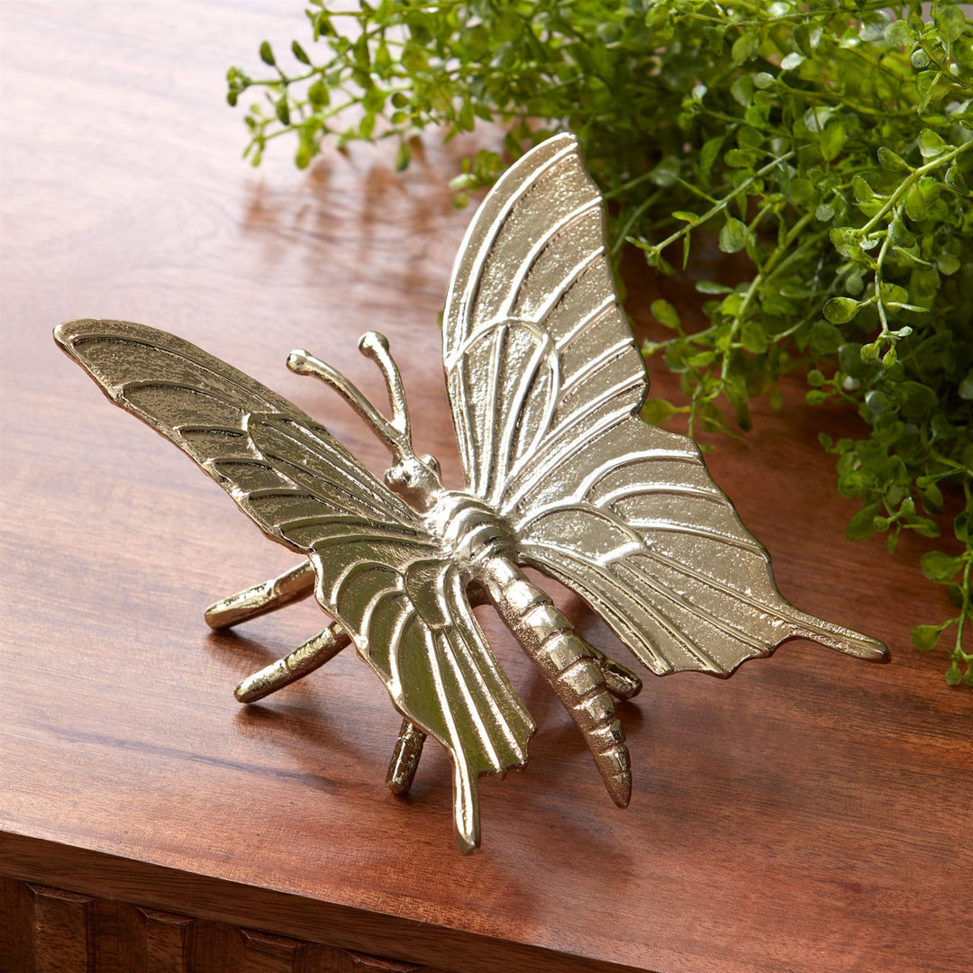 Decorative butterfly on a wooden surface with greenery in the background