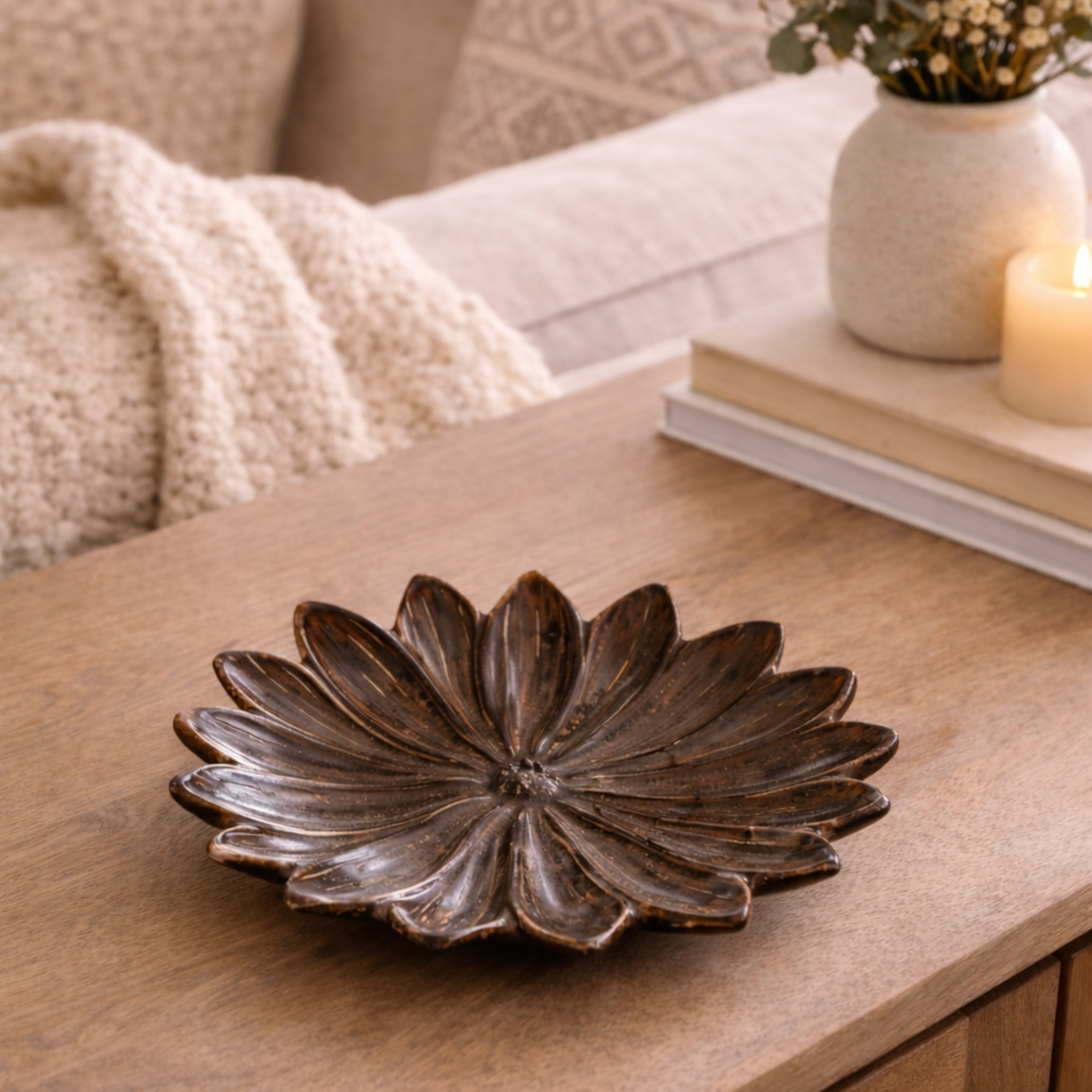 Decorative stoneware flower bowl on a wooden coffee table with a cozy living room setting.