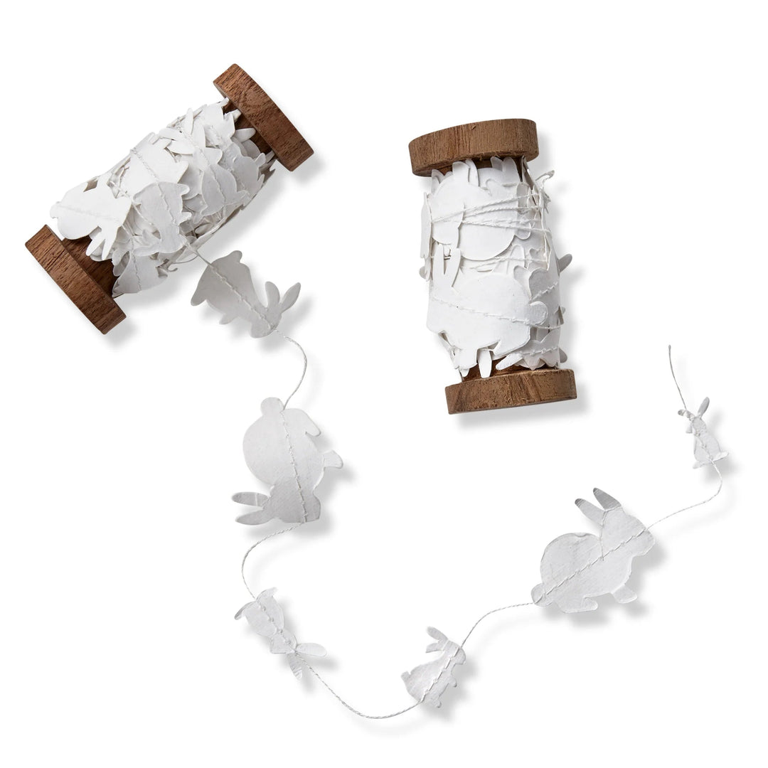 Decorative string lights with bunny shapes on wooden spools against a white background