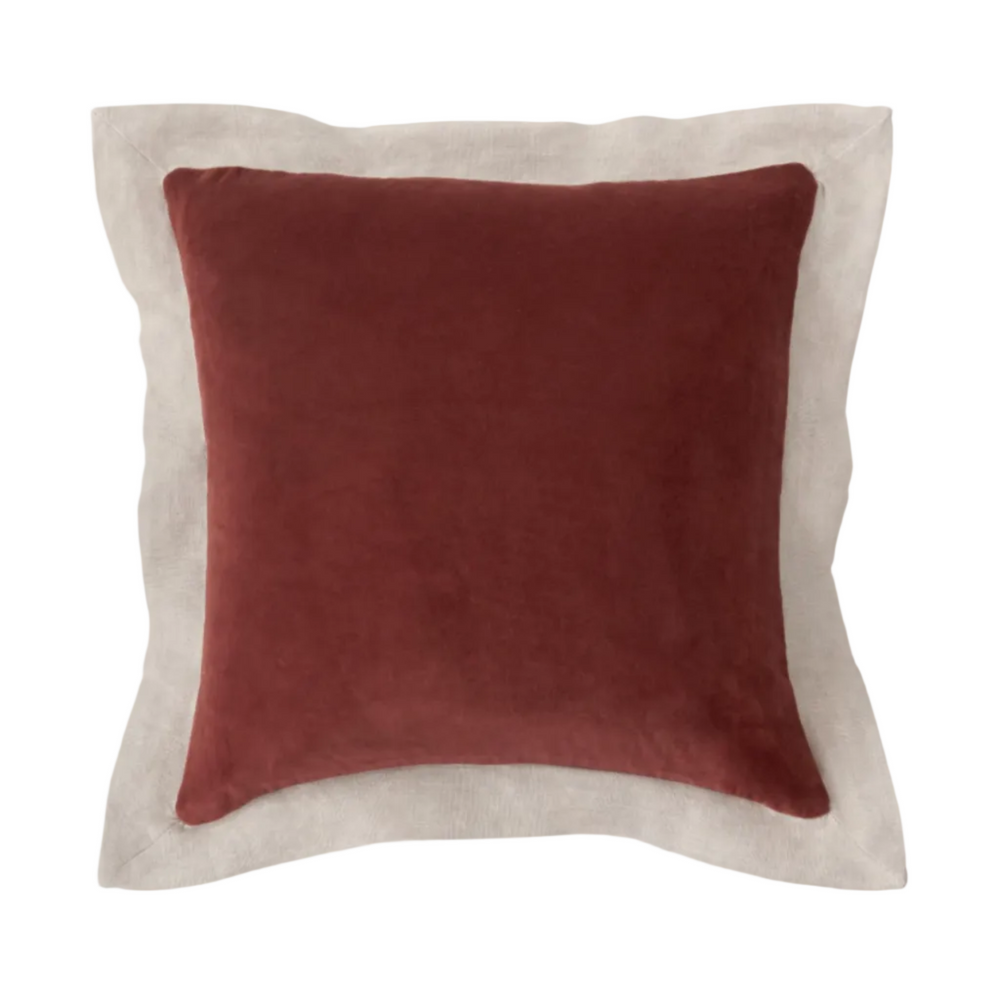 Red pillow with beige border on a white background