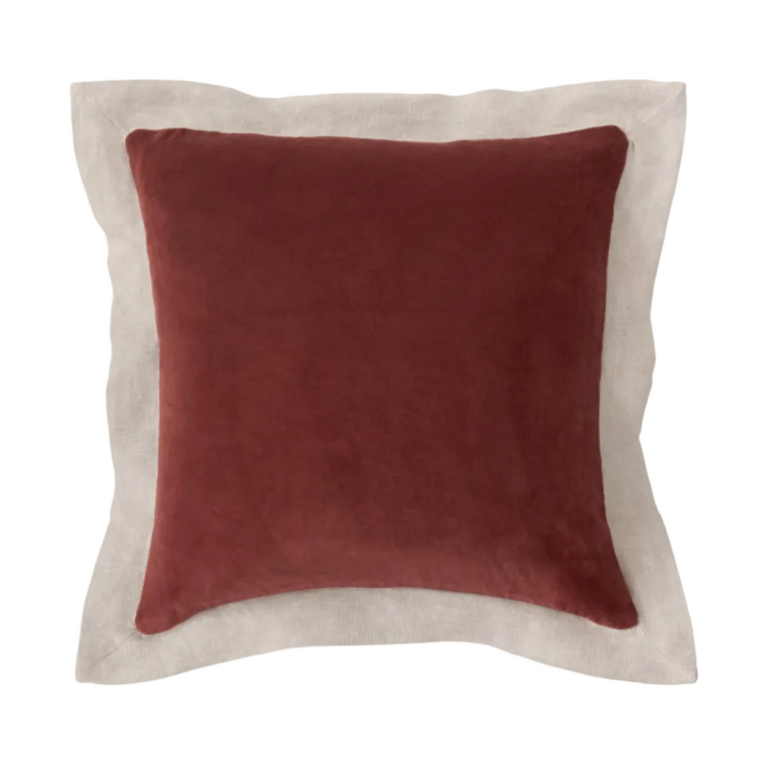Red pillow with beige border on a white background