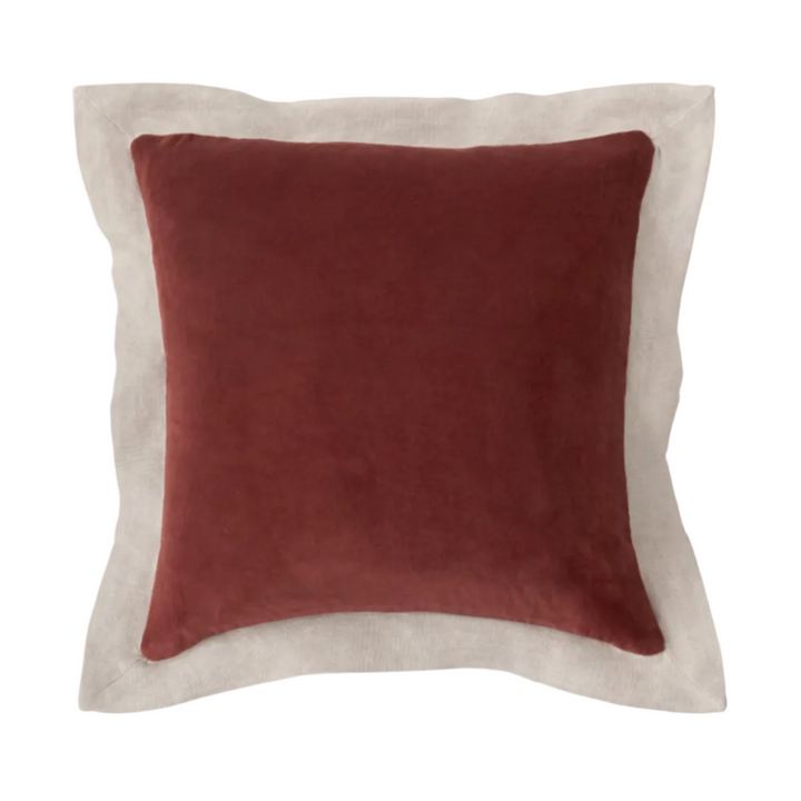Red pillow with beige border on a white background