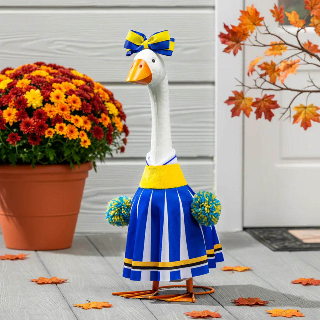 Decorative goose in a blue and yellow outfit with autumn decorations in the background.