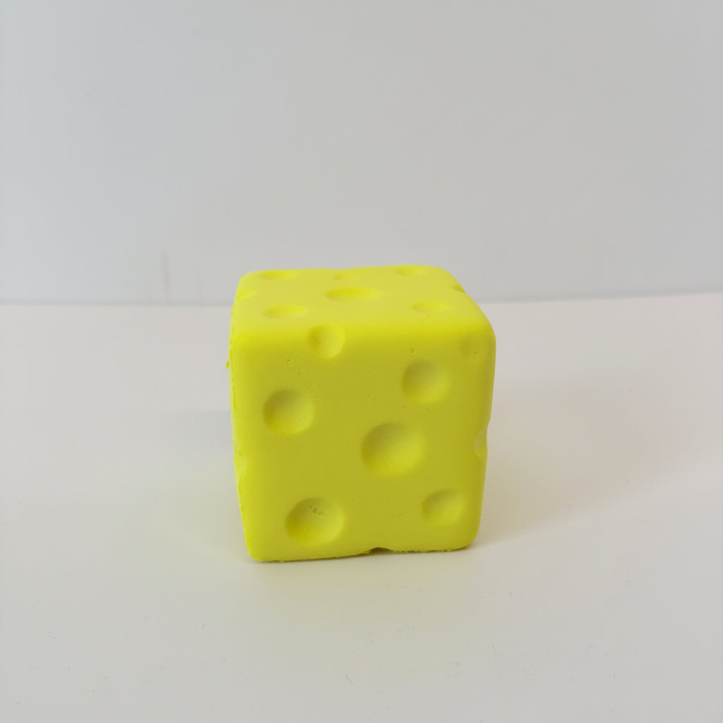 Yellow cube-shaped object resembling cheese on a white background