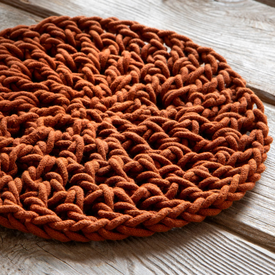 Round brown woven mat on a wooden surface