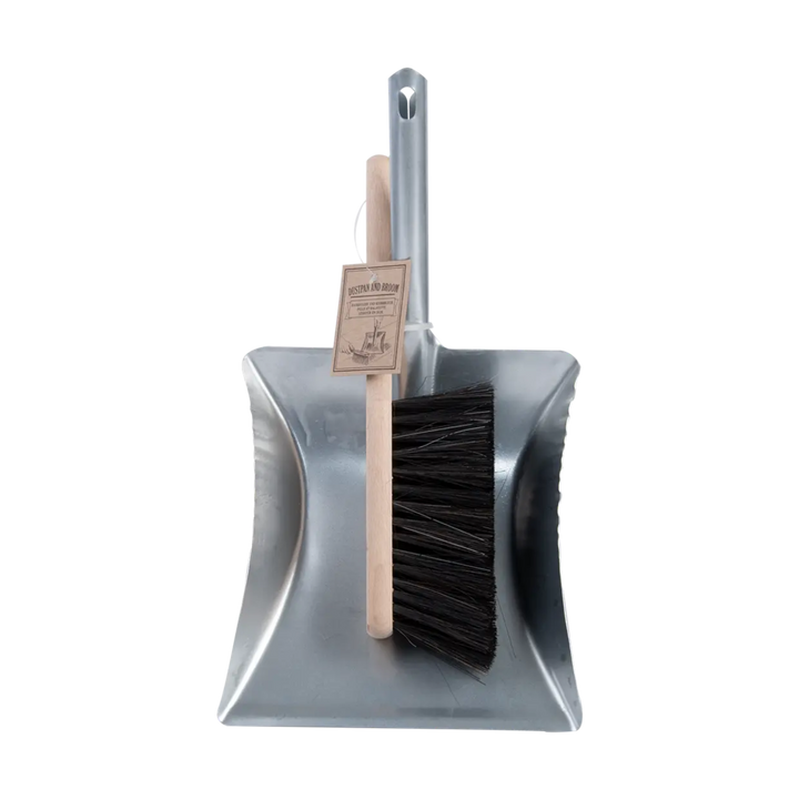Metal dustpan and brush set on a white background