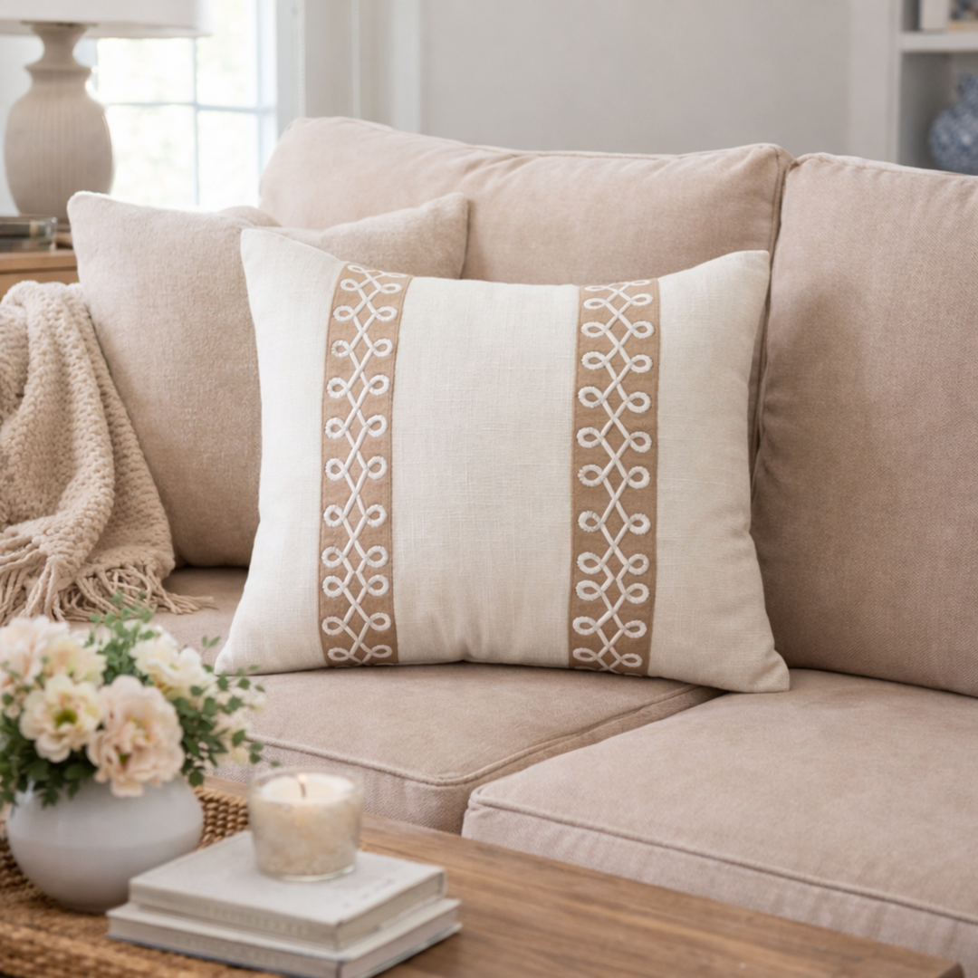 Decorative pillow with intricate patterns on a beige sofa in a cozy living room.