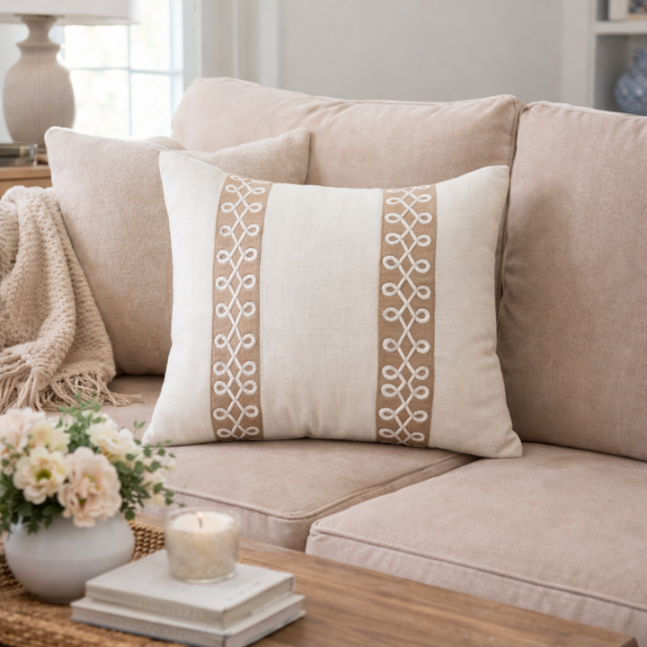 Decorative pillow with intricate patterns on a beige sofa in a cozy living room.