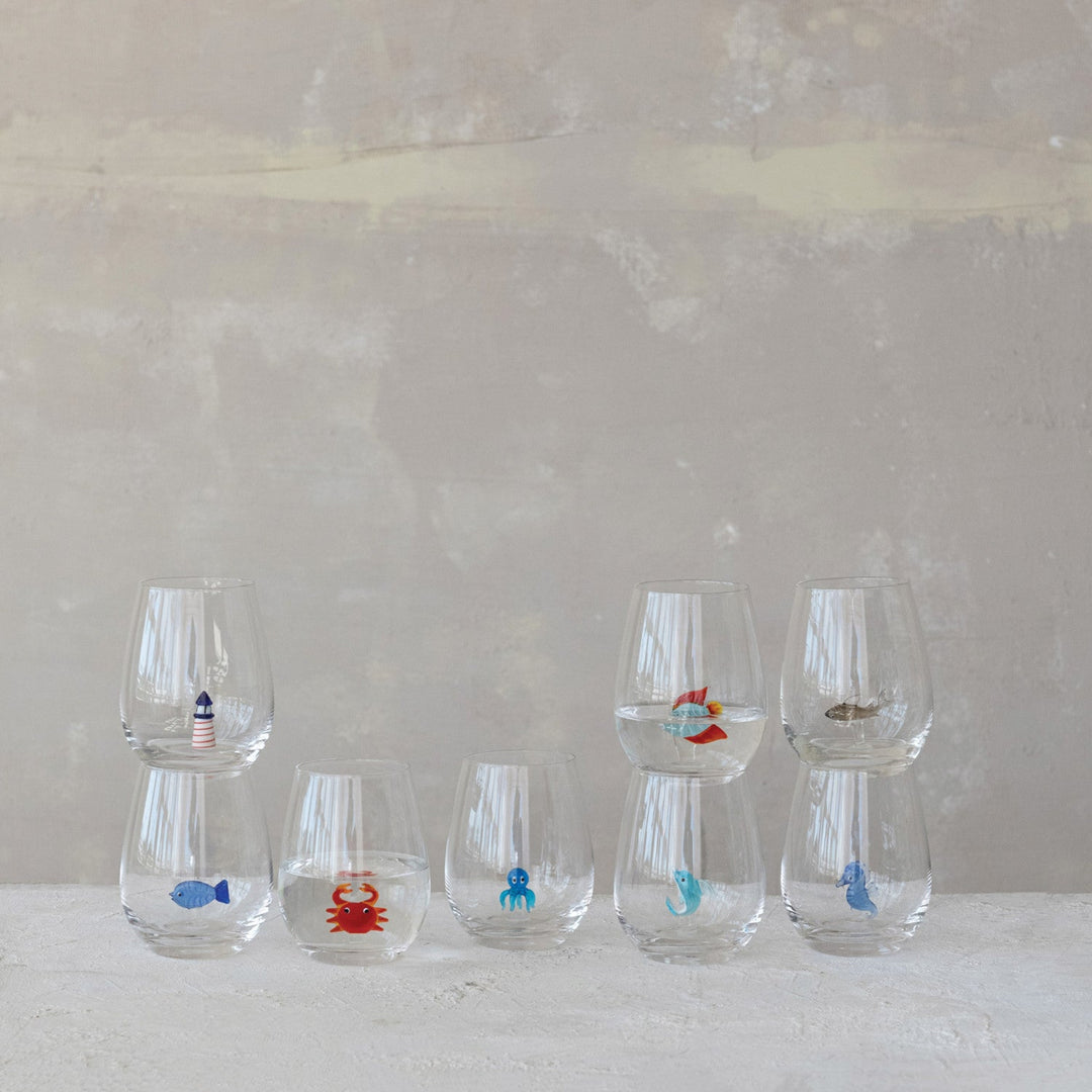 Set of five small glass containers with various animal illustrations on a neutral background