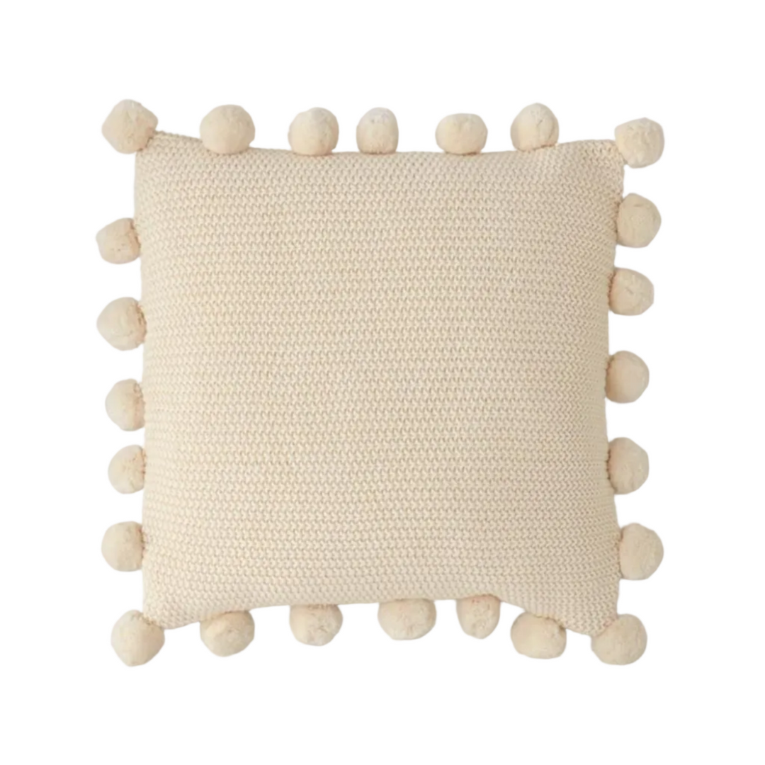 Beige pillow with pom-pom details on a white background