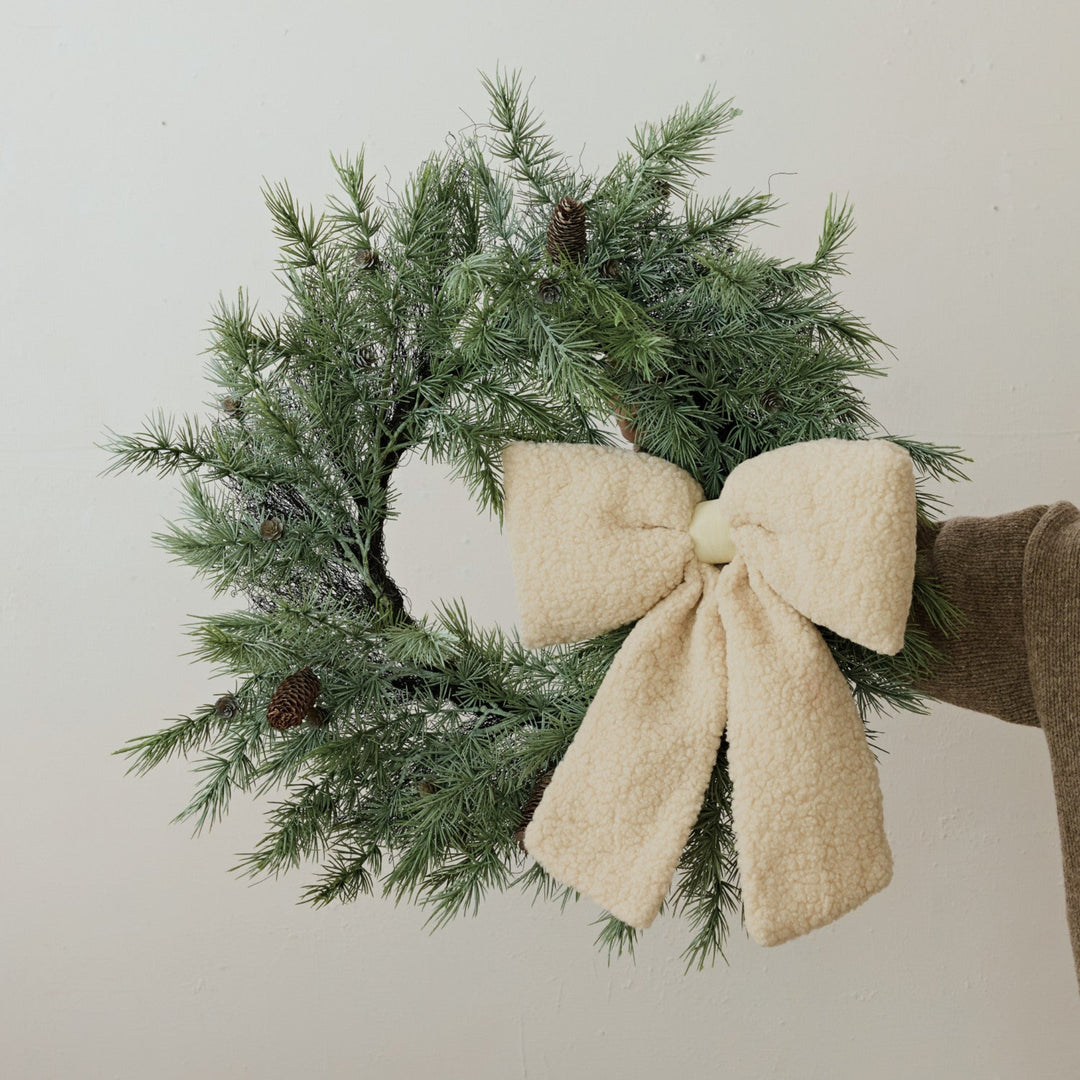 Christmas wreath with a large bow on a plain background
