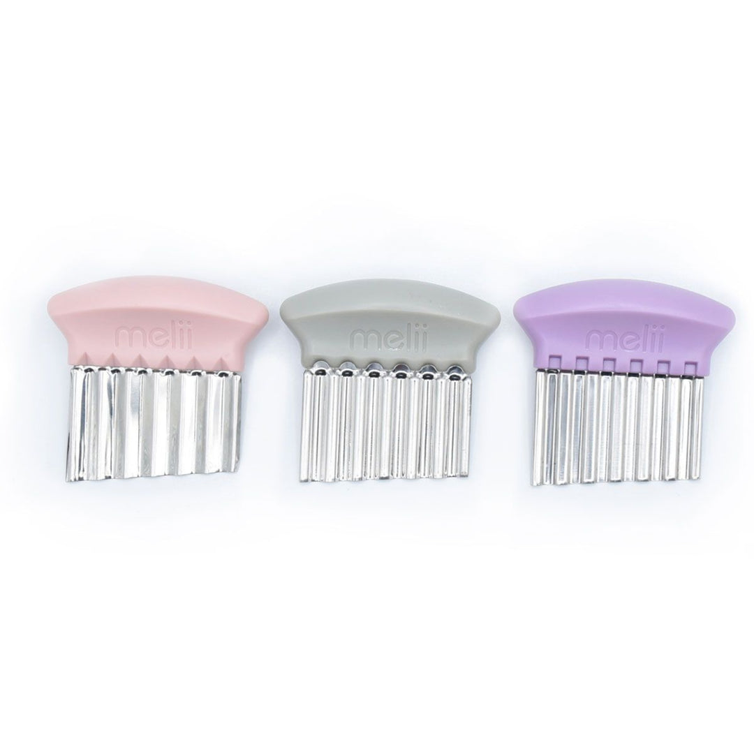 Three pet grooming combs with pink, gray, and purple handles on a white background