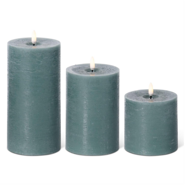 Three gray candles of different sizes on a white background