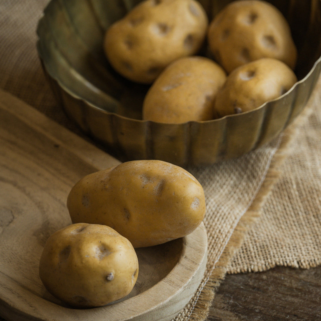 Potatoes in a wooden bowl on a rustic surface