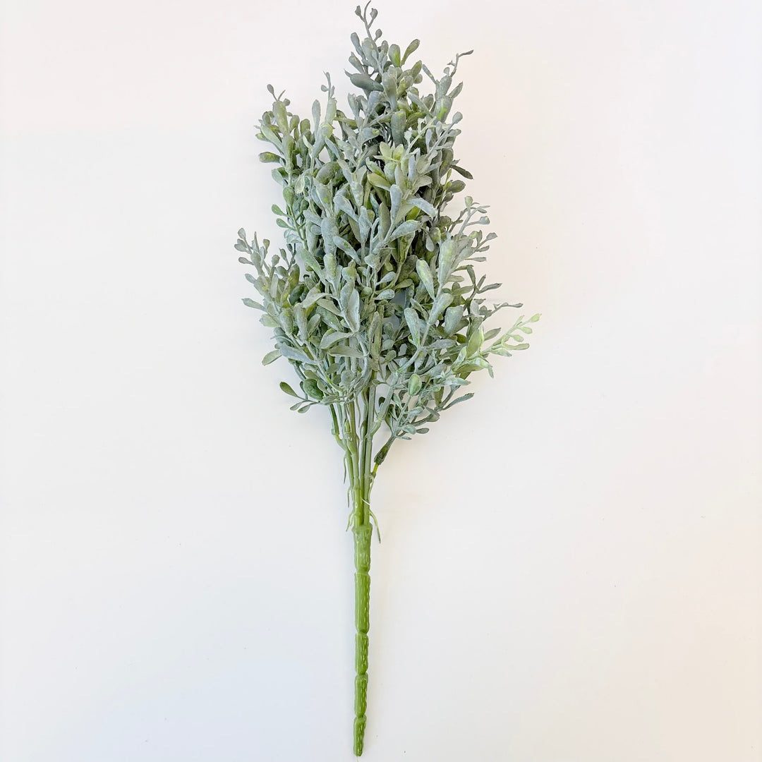 Artificial greenery branch on a white background