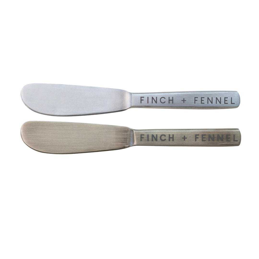 Two metal butter knives with 'Finch + Fennel' branding on a white background