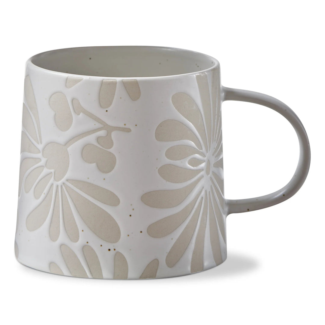 White ceramic mug with beige floral patterns on a white background