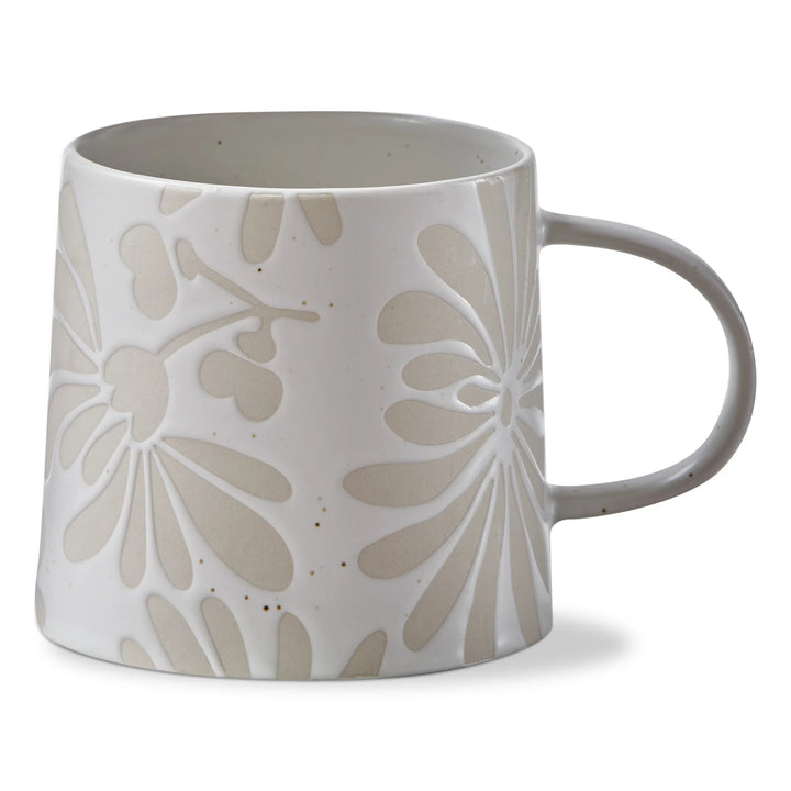 White ceramic mug with beige floral patterns on a white background