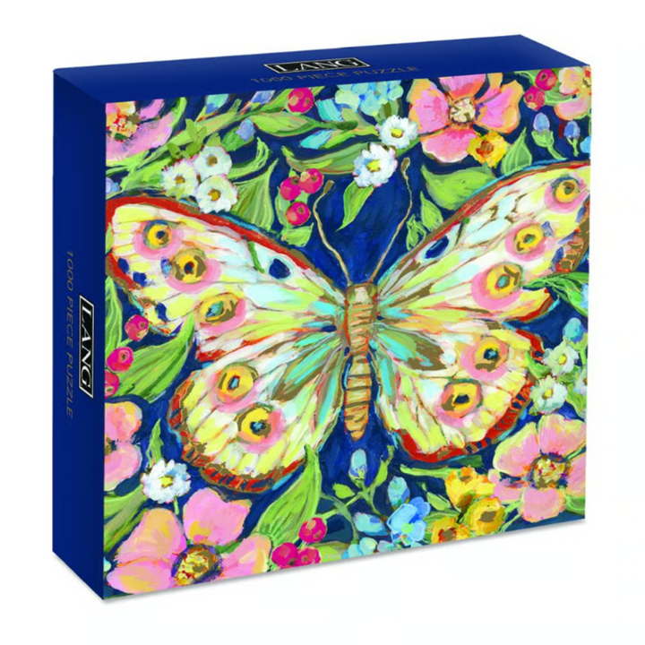 A boxed puzzle featuring a colorful painted butterfly surrounded by flowers on a dark blue background. The front shows the artwork, and the side of the box reads '1000 pieces' and 'L'ECLECI'.