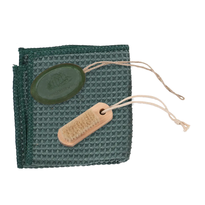 Green waffle-textured cloth with a wooden brush and a green label on a white background