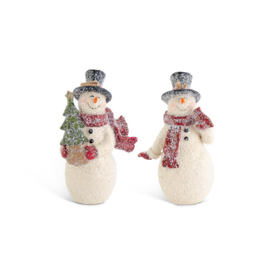 Two snowman figurines with textured off-white bodies, black top hats, red scarves, and orange carrot noses, posed side by side on a white background. One snowman holds a small green glittery Christmas tree.