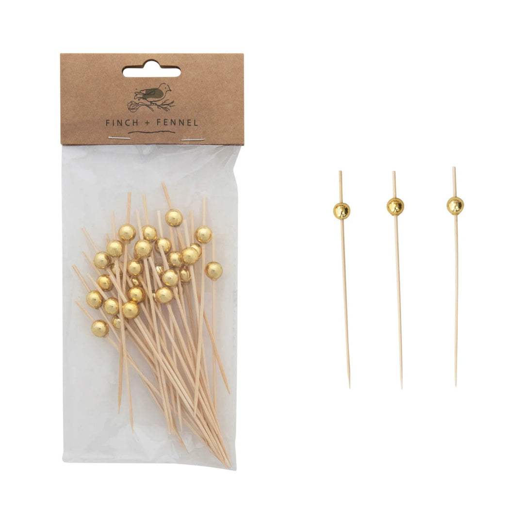 Packaged gold toothpicks with a visible brand label on a white background