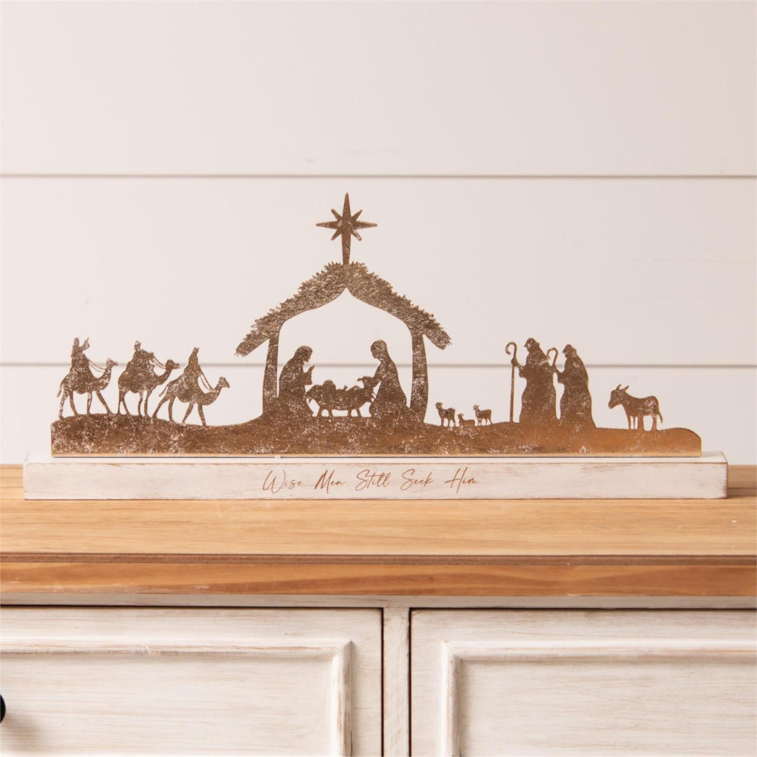 Decorative nativity scene on a wooden shelf with a white background