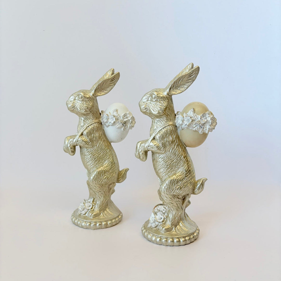 Two decorative rabbit figurines with pearl-like beads on a light background
