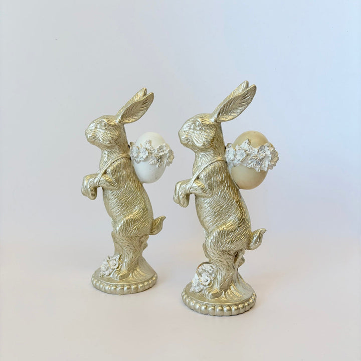 Two decorative rabbit figurines with pearl-like beads on a light background