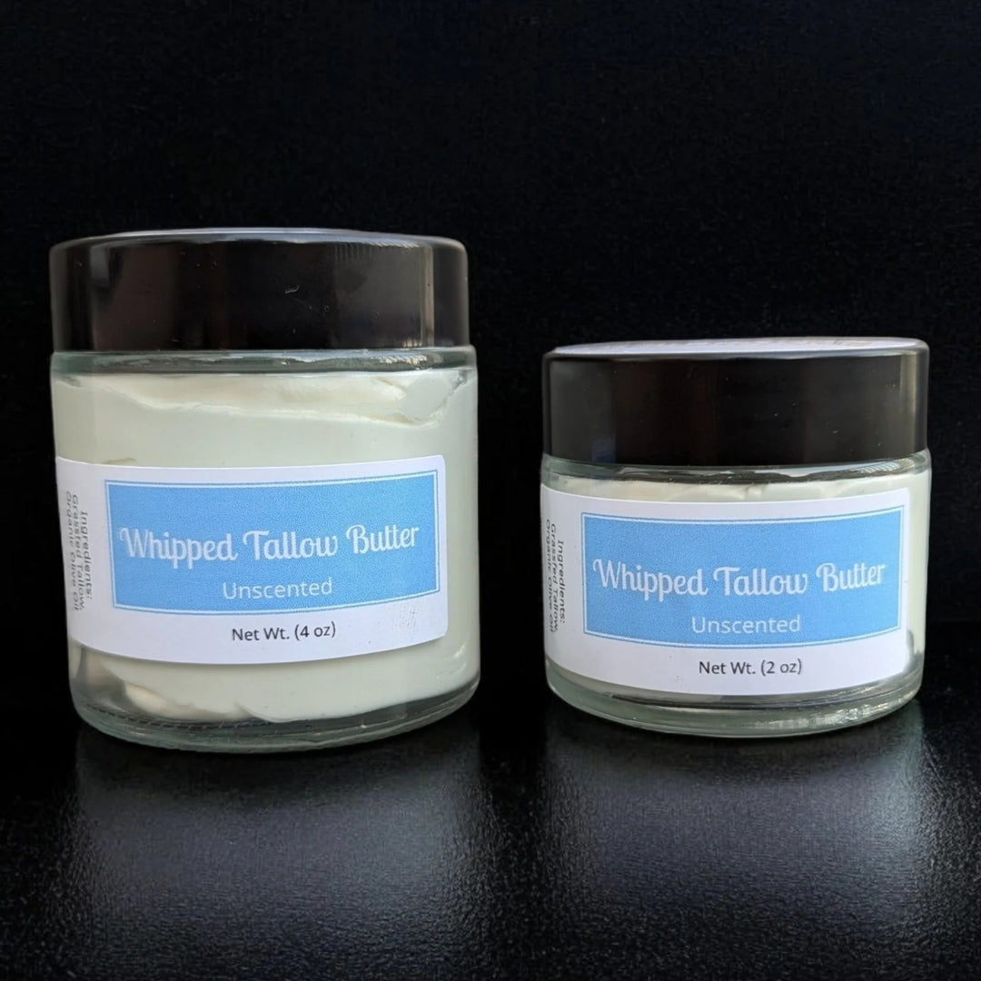 Two jars of Whipped Tallow Butter with labels on a black background