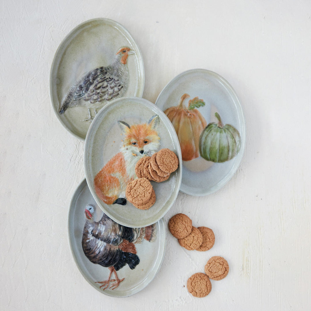 Set of four decorative plates with animal and nature-themed designs on a light background.