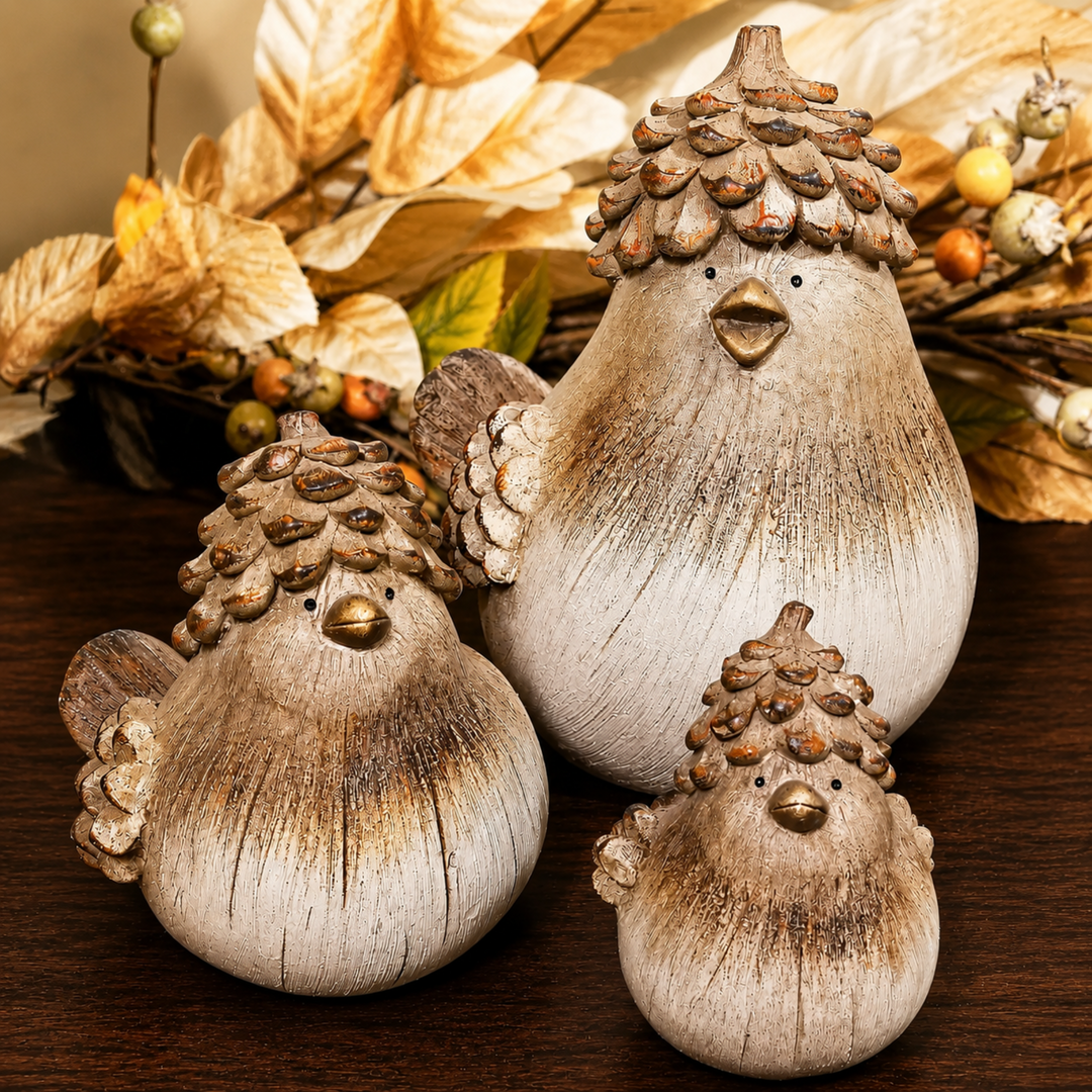 Three rustic decorative bird figurines with textured, weathered wood-like finishes and pinecone-style hats, arranged on a dark wooden surface with dried autumn leaves in the background.