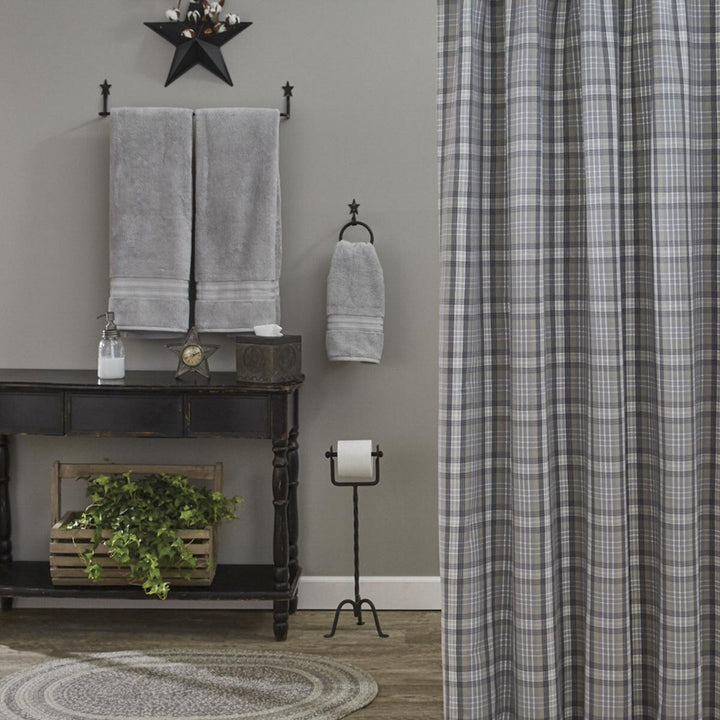 Bathroom interior with towels, a star decoration, and a plaid shower curtain.