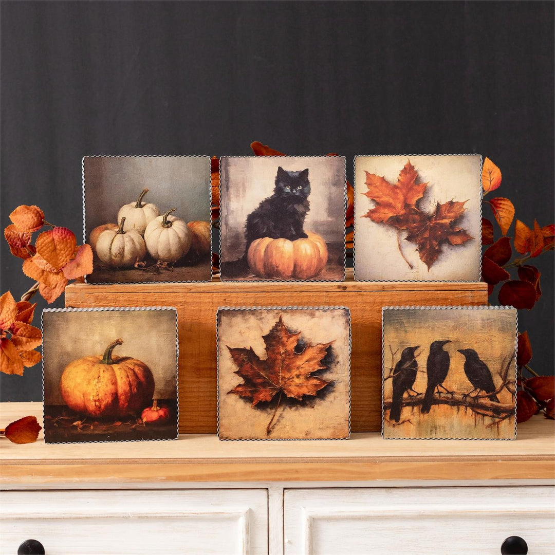 Set of decorative panels with autumn-themed images on a wooden stand.