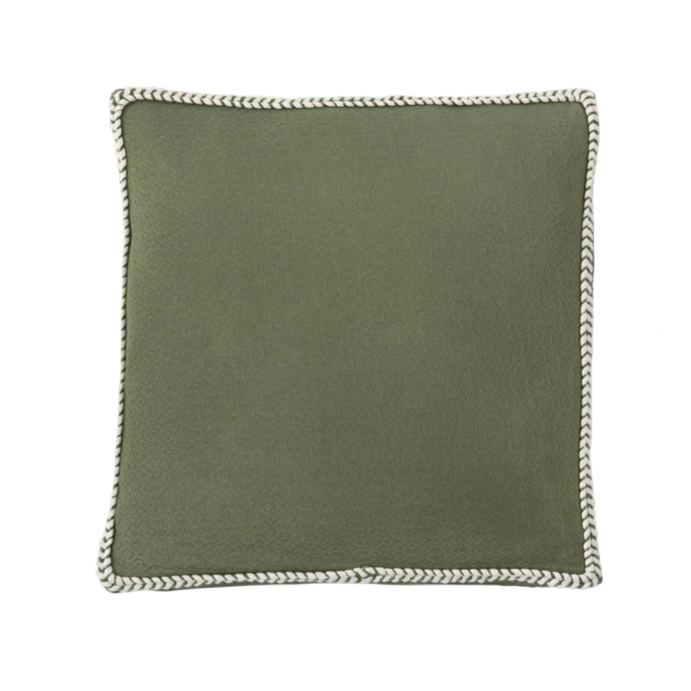 Green pillow with braided edge on a white background