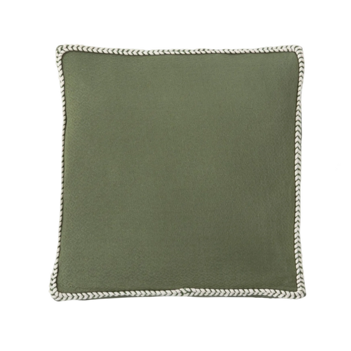 Green pillow with braided edge on a white background