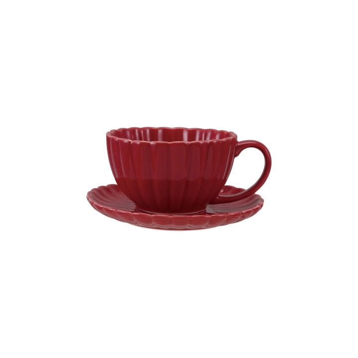 Red ceramic teacup and saucer on a white background