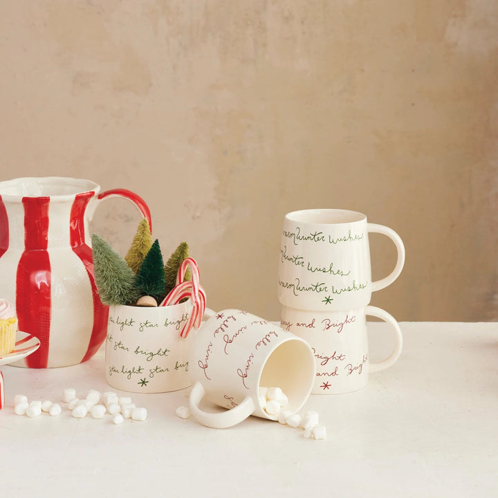 Set of mugs with Christmas-themed designs on a neutral background